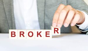 Hand creating the word "broker" with blocks